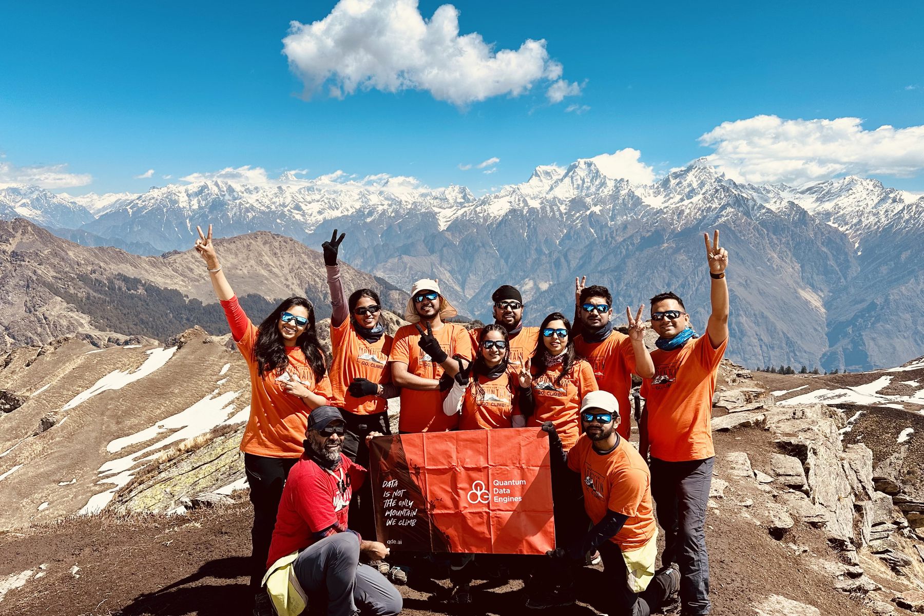 The QDE team on the Kuari Pass summit ridge with snow peaks behind