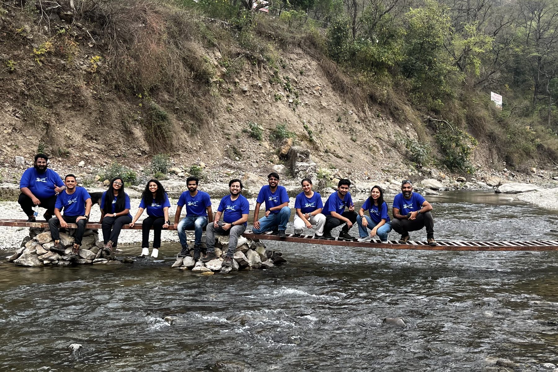 The QDE team crossing a mountain river on a log bridge in the Kuari Pass valley